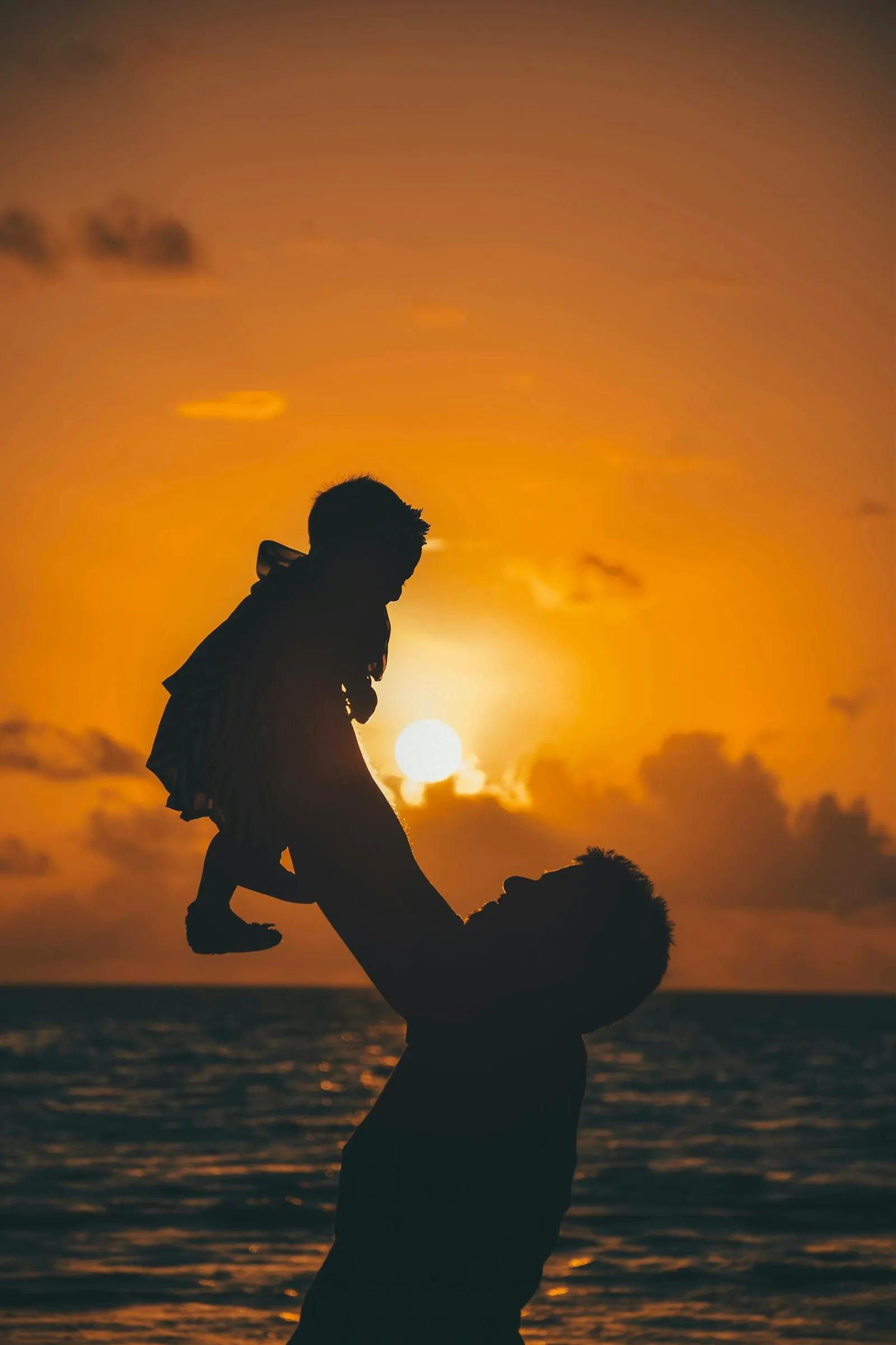 Father carrying a child during golden hour