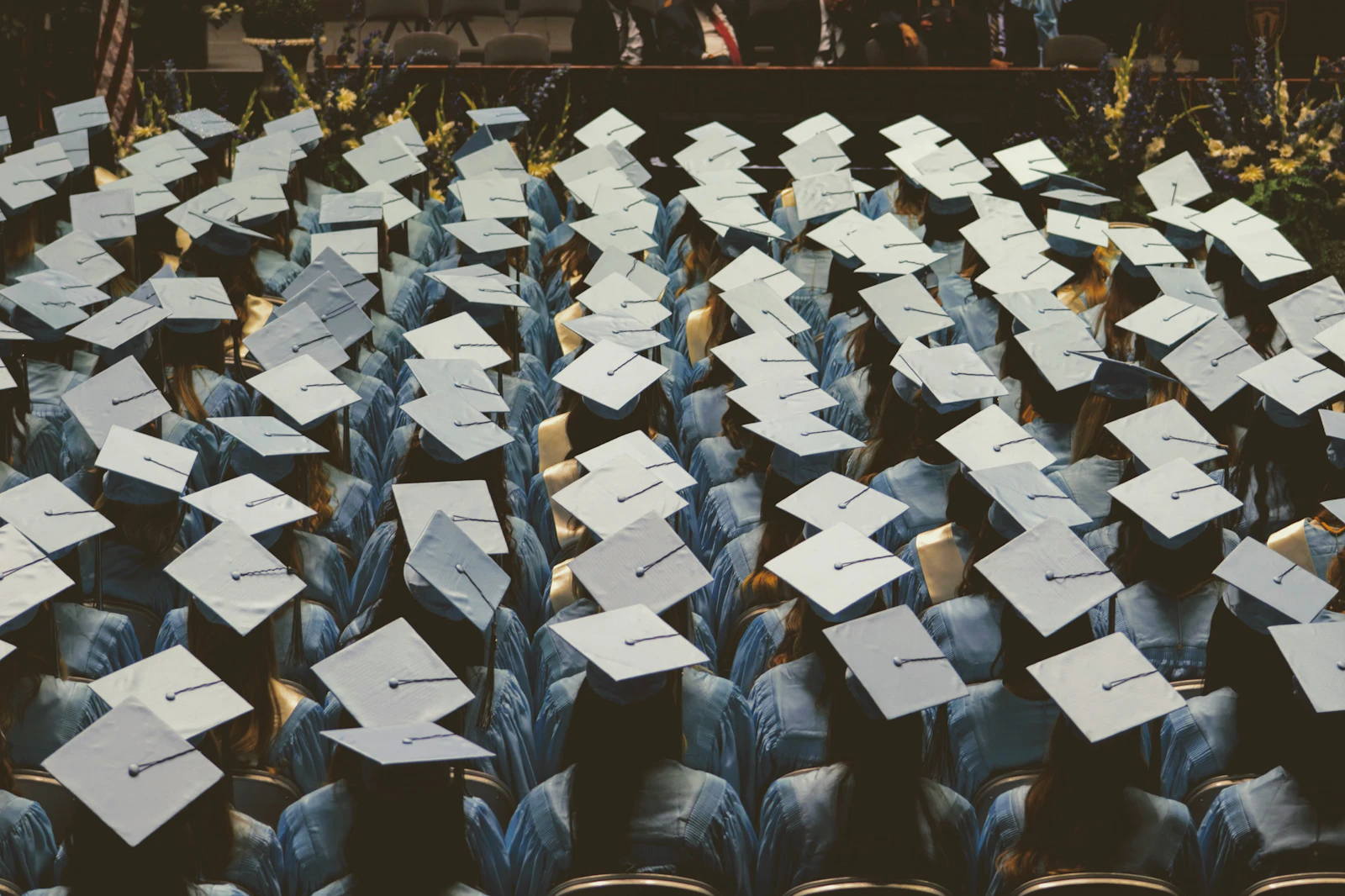Graduation caps thrown in the air against a blue sky