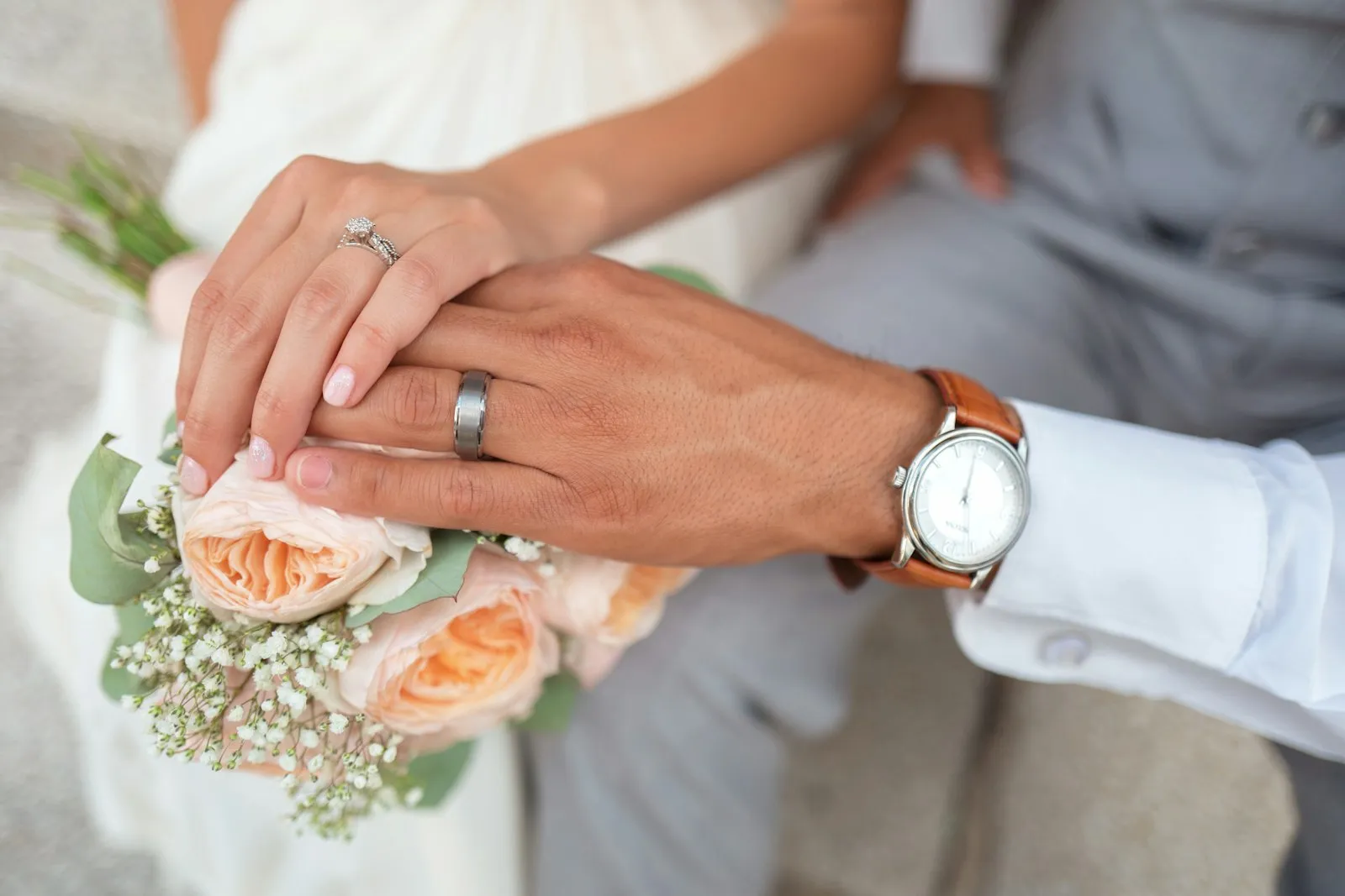 Couple holding hands wearing wedding rings