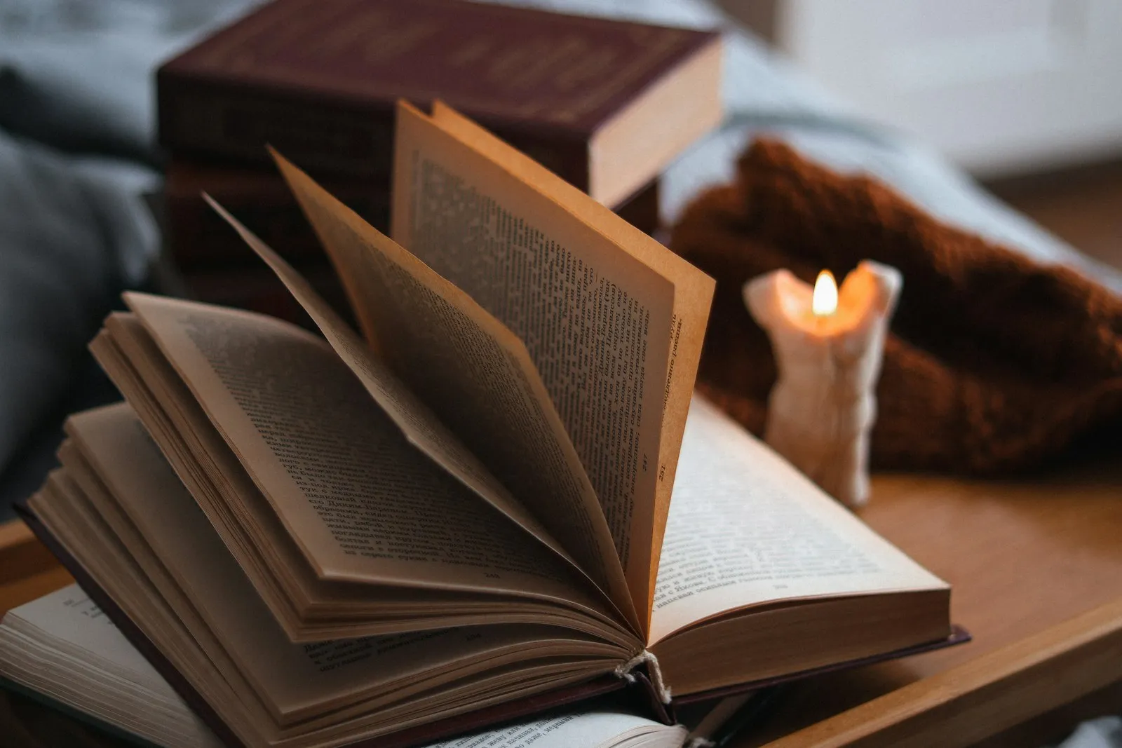 Open book beside a lit candle
